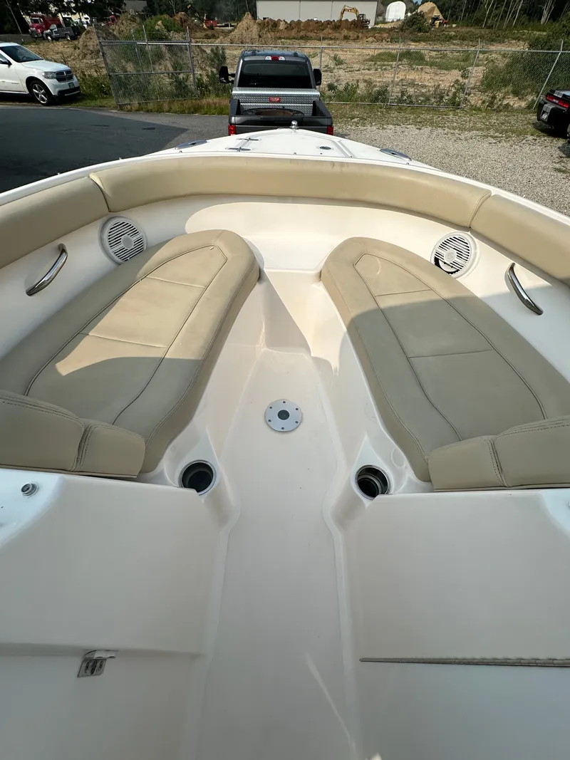 Slide: The Image of 2016 Pursuit DC 265 Dual Console boat interior with beige seating and cup holders. - 12
