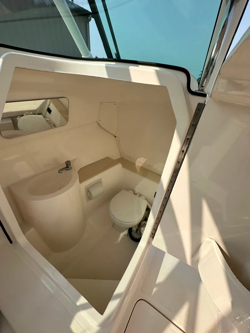 Slide: The Image of 2016 Pursuit DC 265 Dual Console boat interior with compact bathroom amenities. - 15