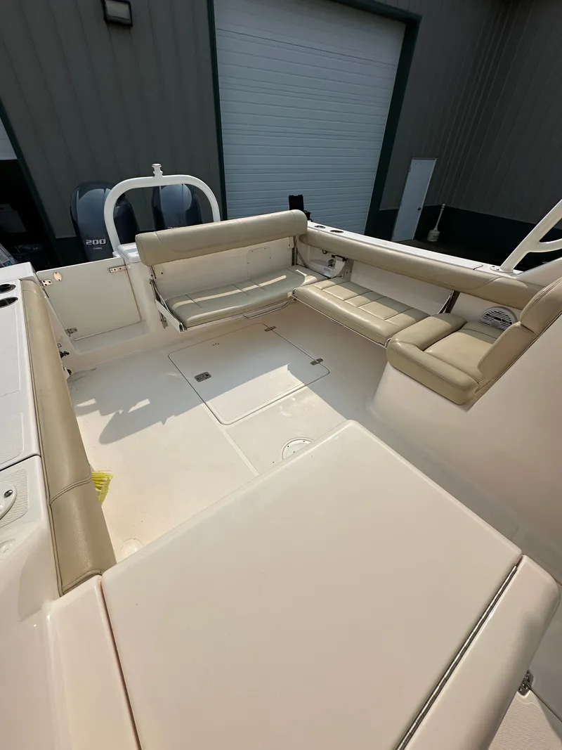 Slide: The Image of 2016 Pursuit DC 265 Dual Console boat interior with beige seating and spacious deck. - 6