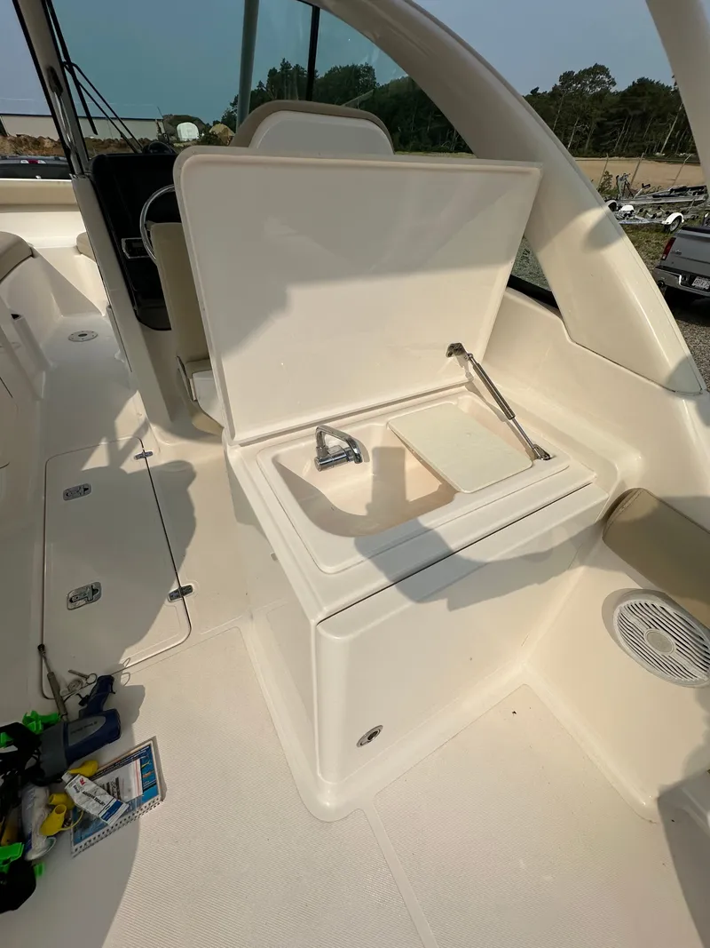 Slide: The Image of 2016 Pursuit DC 265 Dual Console boat interior with sink and storage area. - 7