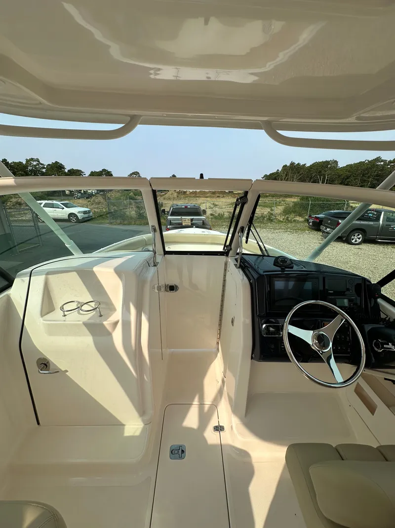 Slide: The Image of 2016 Pursuit DC 265 Dual Console boat interior with steering wheel and dashboard. - 9