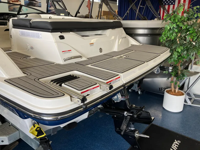 Slide: The Image of 2023 Sea Ray SPX 210 boat rear view in showroom, featuring swim platform and seating. - 9