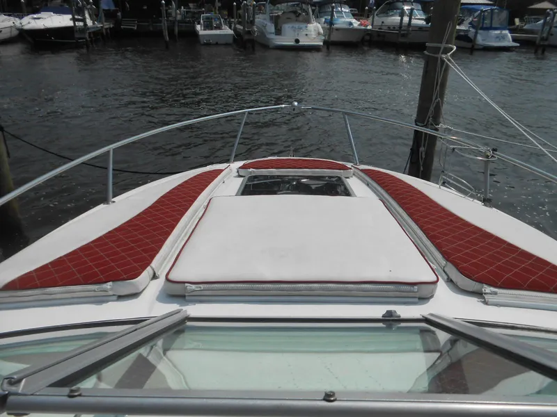 Slide: The Image of 2014 Chaparral 270 Signature boat bow with red cushions, docked in a marina. - 15