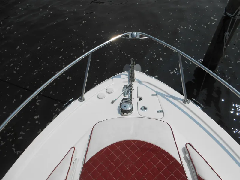 Slide: The Image of 2014 Chaparral 270 Signature boat bow with red seating and anchor, on calm water. - 16