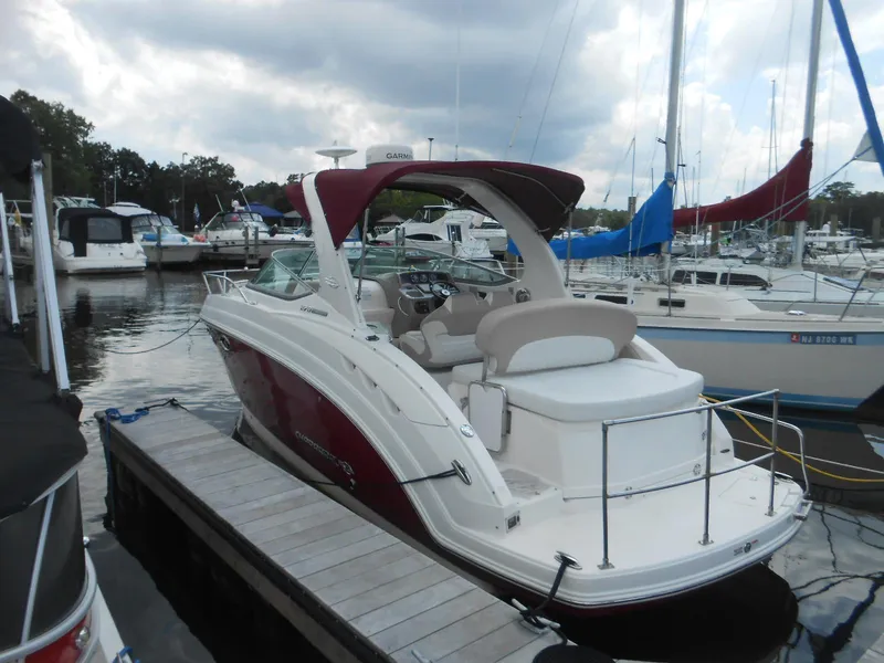 Slide: The Image of 2014 Chaparral 270 Signature boat docked at a marina under cloudy skies. - 2