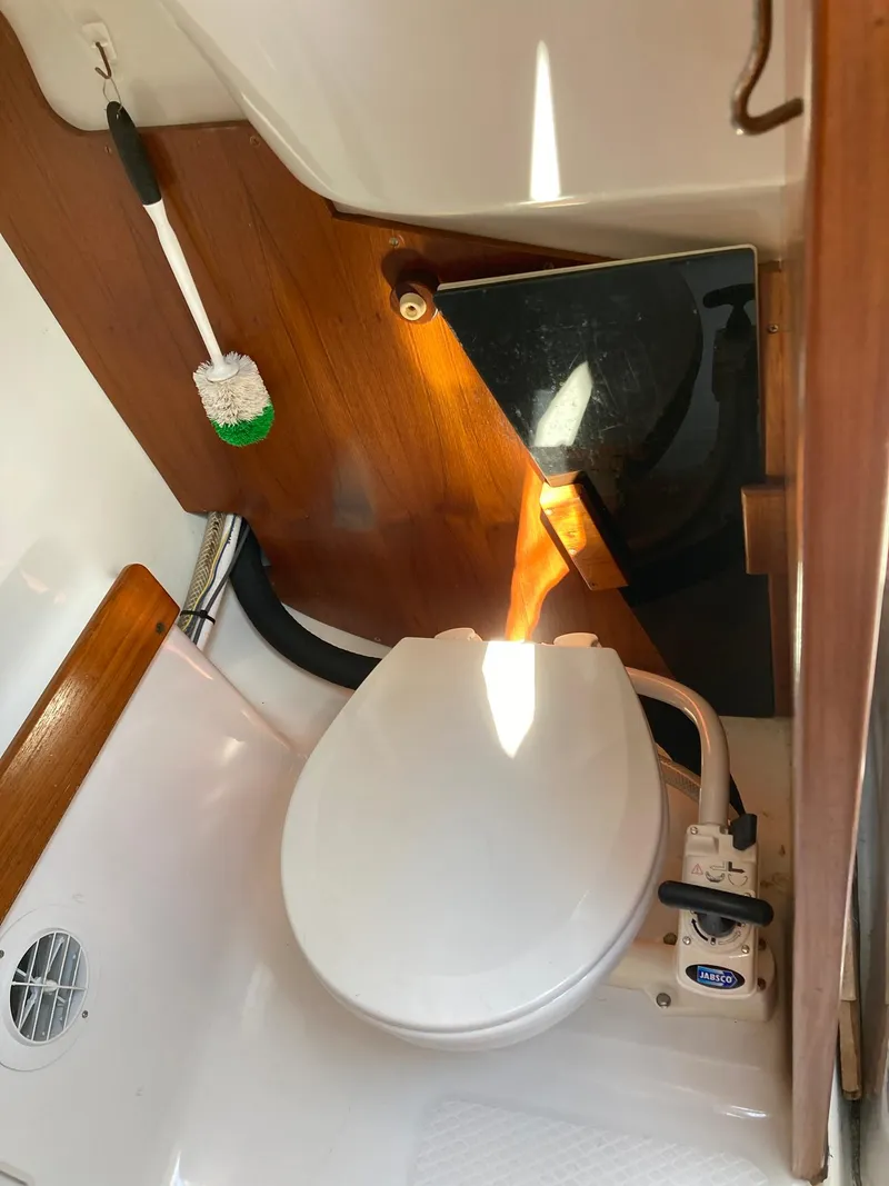 Slide: The Image of 2006 Hake Seaward 26RK boat bathroom with toilet and cleaning brush. - 5