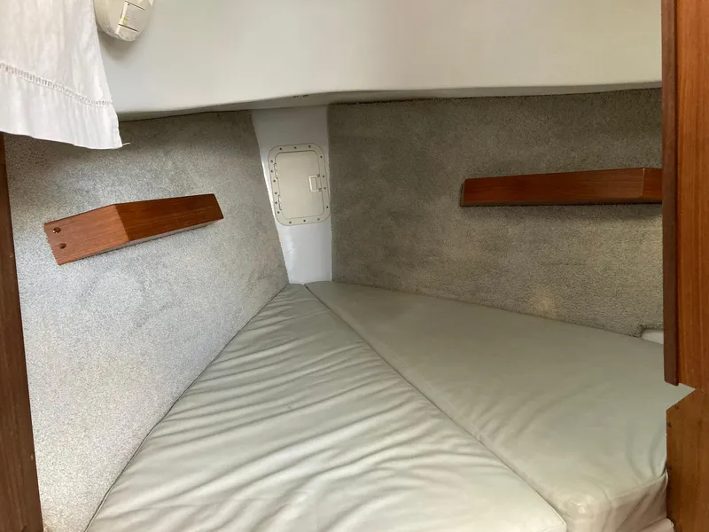 Slide: The Image of 2006 Hake Seaward 26RK cabin interior with cushioned berth and wooden accents. - 8