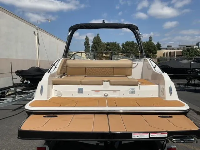 Slide: The Image of 2025 Bayliner D22I boat with tan seating and spacious deck under a clear sky. - 7