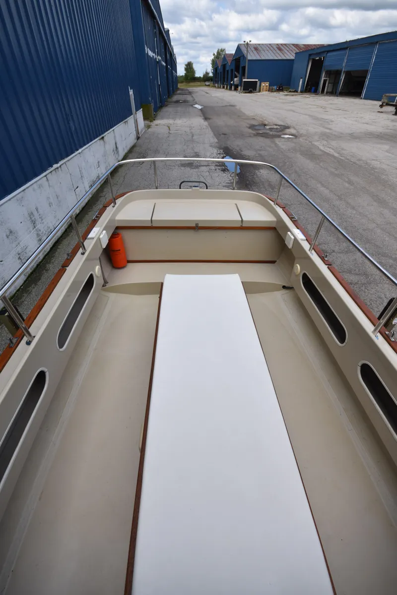 Slide: The Image of 1994 Ranger Tugs R21 boat interior, docked near blue warehouses. - 13