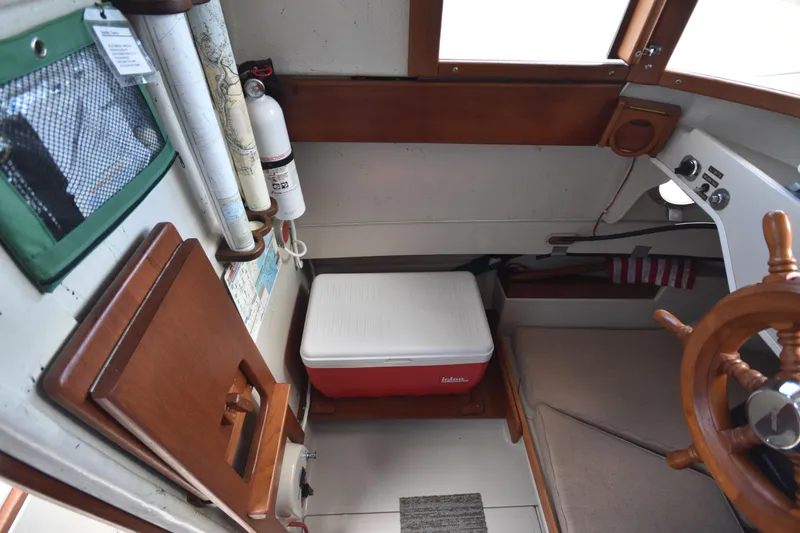 Slide: The Image of Interior of 1994 Ranger Tugs R21 boat with wooden accents and a red cooler. - 23