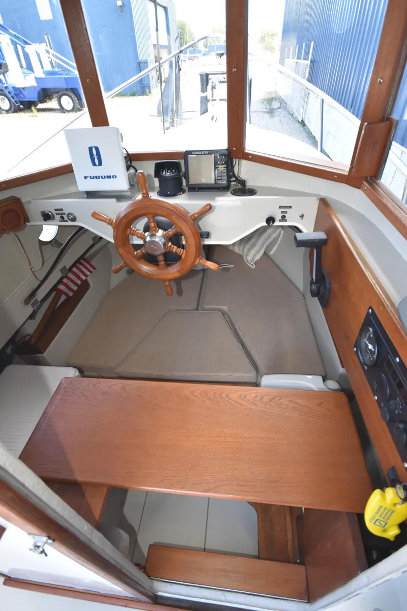 Slide: The Image of Interior view of 1994 Ranger Tugs R21 boat with wooden steering wheel and navigation equipment. - 25
