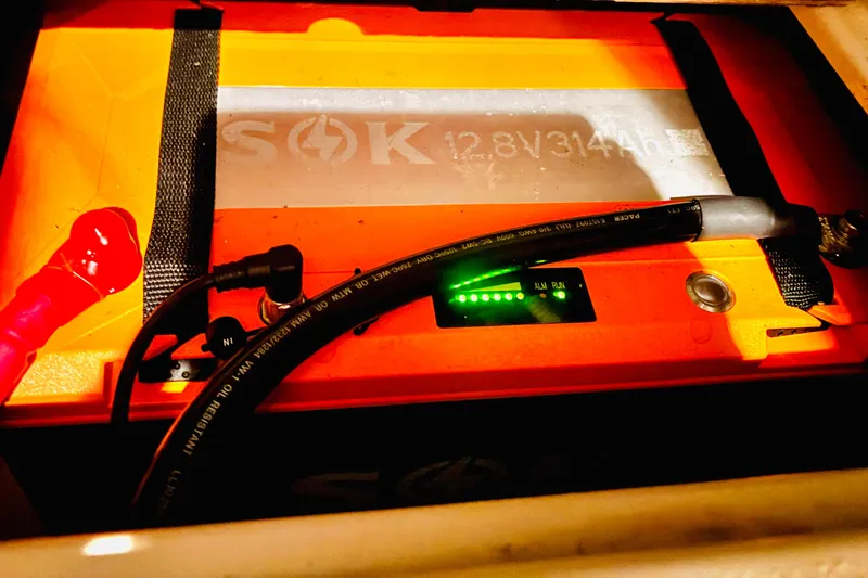 Slide: The Image of Battery compartment of a 2001 Island Packet 420 sailboat, featuring a SOK 12.8V battery. - 38