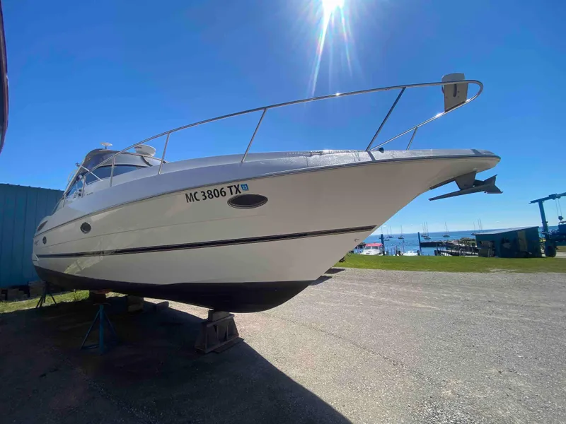 Slide: The Image of 2004 Cruisers Yachts 340 Express on stands, outdoor storage, clear blue sky. - 3