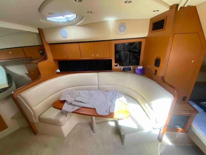 Slide: The Image of 2004 Cruisers Yachts 340 Express interior with seating, table, and kitchenette. - 32