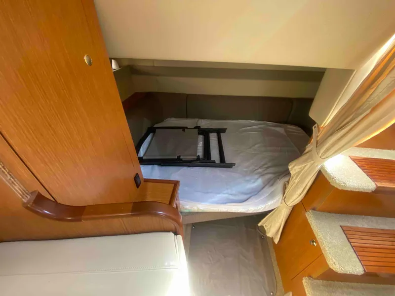 Slide: The Image of Interior of 2004 Cruisers Yachts 340 Express with curved seating and wooden table. - 33