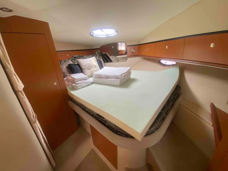 Slide: The Image of 2004 Cruisers Yachts 340 Express cabin interior with bed and wooden accents. - 34