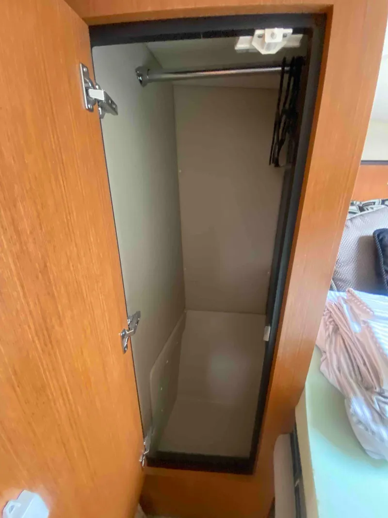 Slide: The Image of 2004 Cruisers Yachts 340 Express cabin interior with bed and storage cabinets. - 35