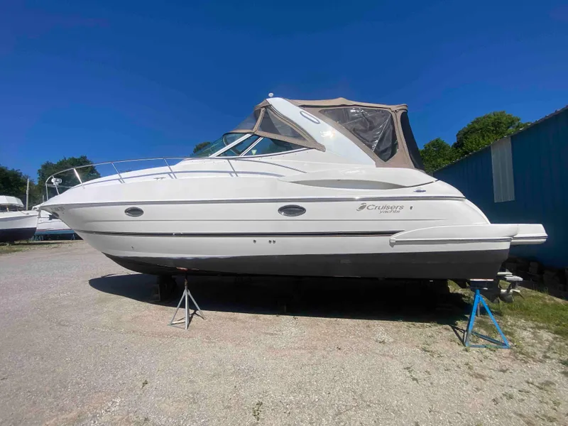 Slide: The Image of 2004 Cruisers Yachts 340 Express on stands, white hull, clear sky background. - 1
