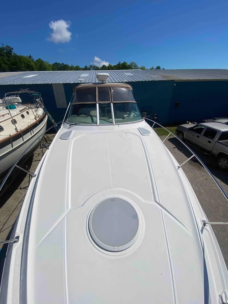 Slide: The Image of 2004 Cruisers Yachts 340 Express boat docked near blue building. - 28