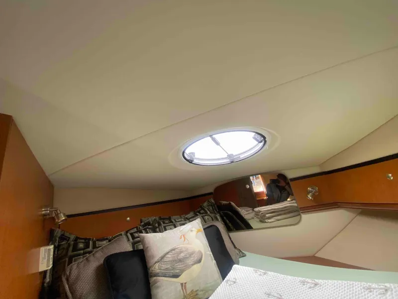 Slide: The Image of Interior of 2004 Cruisers Yachts 340 Express, featuring elegant wood cabinetry and ceiling design. - 47