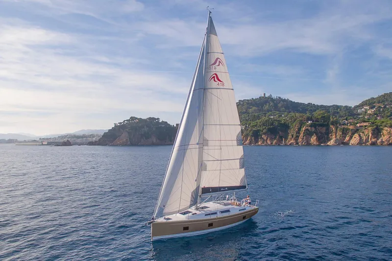 The Image of 2025 Hanse 418 sailboat cruising near scenic coastline under clear skies. - 0