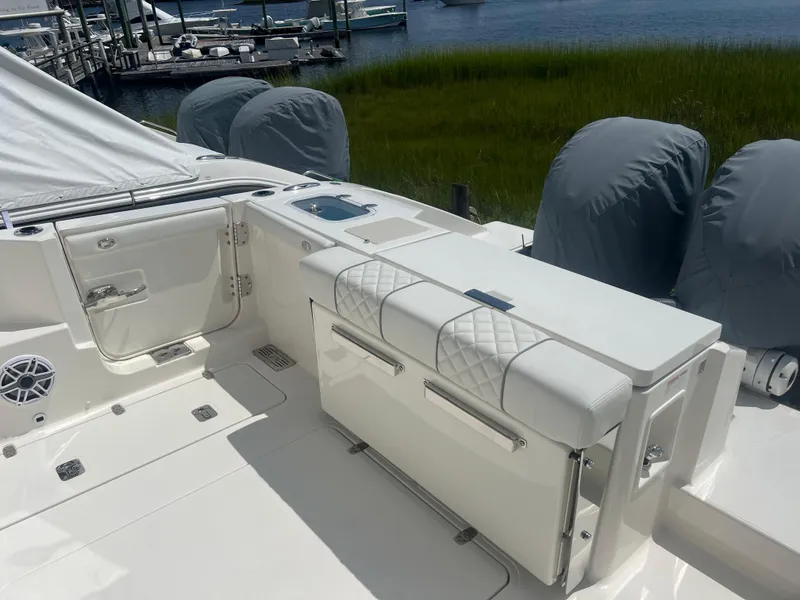 Slide: The Image of 2024 Pursuit DC 306 Dual Console boat interior with seating and covered engines. - 10