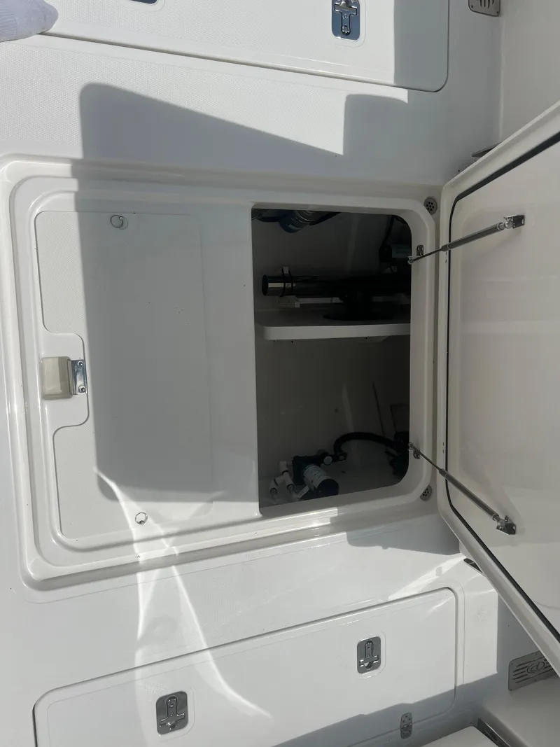 Slide: The Image of 2024 Pursuit DC 306 Dual Console storage compartment, open and empty. - 13