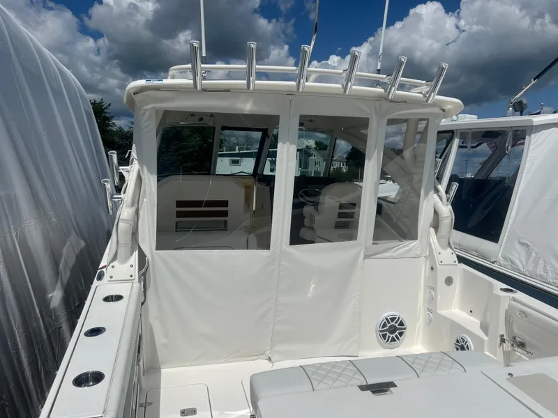 Slide: The Image of 2024 Pursuit DC 306 Dual Console boat with covered seating area and rod holders. - 16