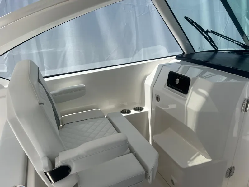 Slide: The Image of 2024 Pursuit DC 306 Dual Console interior with white seating and dashboard. - 20