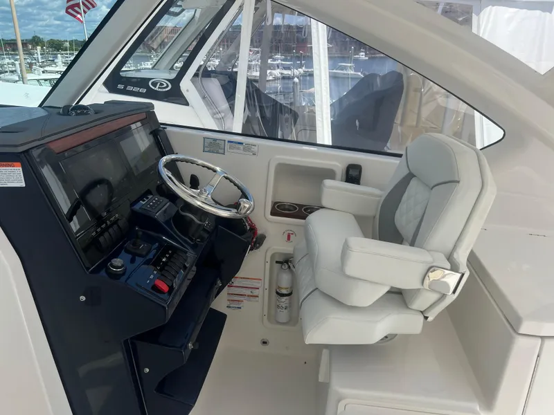 Slide: The Image of 2024 Pursuit DC 306 Dual Console boat helm with steering wheel and captain's chair. - 21