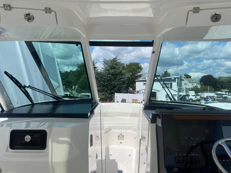 Slide: The Image of 2024 Pursuit DC 306 Dual Console boat interior with windshield and control panel. - 23