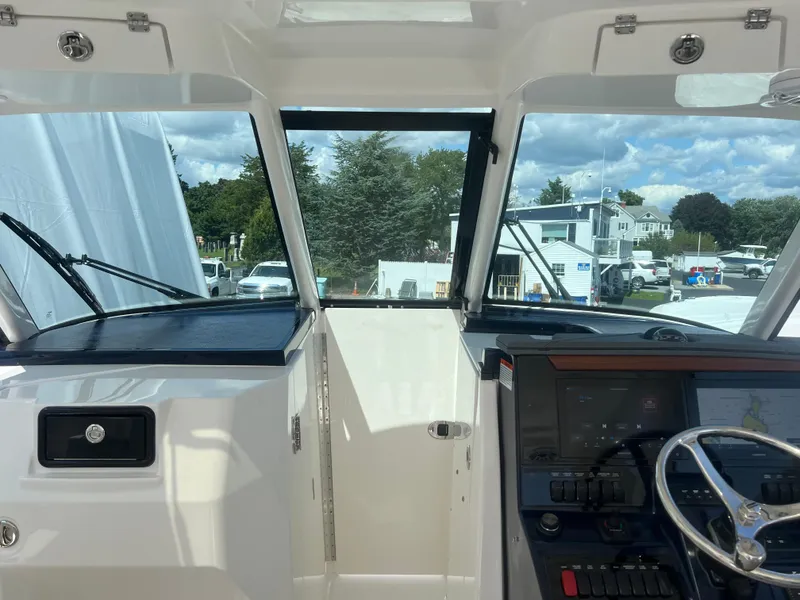 Slide: The Image of 2024 Pursuit DC 306 Dual Console boat interior with steering wheel and dashboard controls. - 24
