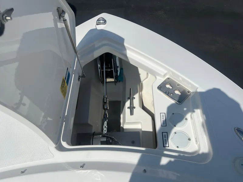 Slide: The Image of 2024 Pursuit DC 306 Dual Console anchor compartment with open hatch and chain storage. - 30