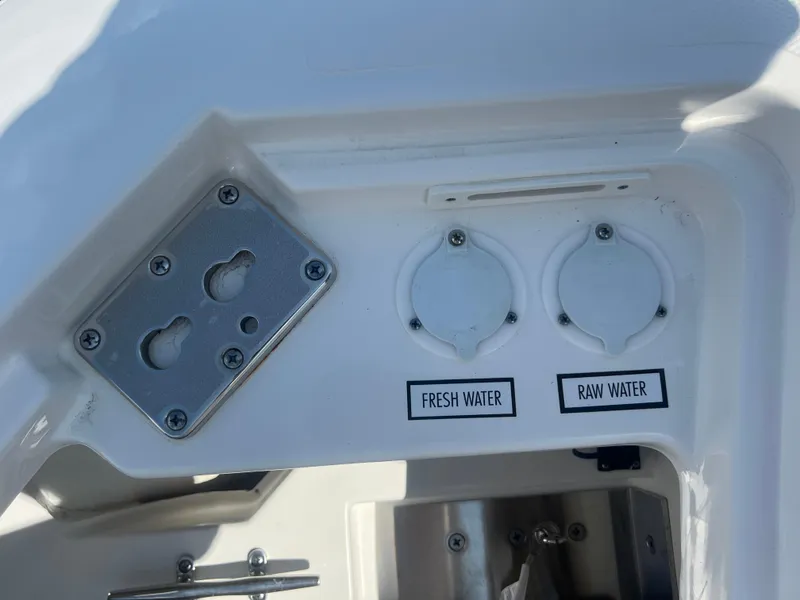 Slide: The Image of 2024 Pursuit DC 306 Dual Console water access panel with fresh and raw water labels. - 31