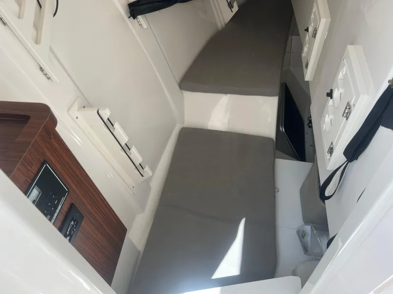 Slide: The Image of 2024 Pursuit DC 306 Dual Console cabin interior with gray cushions and control panel. - 32