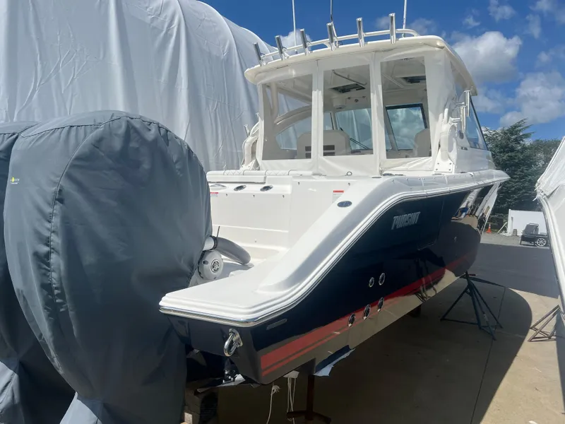 Slide: The Image of 2024 Pursuit DC 306 Dual Console boat, docked, with covered engines, under a clear blue sky. - 4