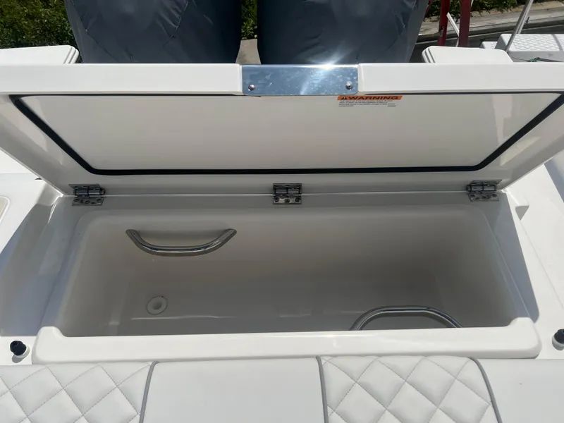 Slide: The Image of Open storage compartment on 2024 Pursuit DC 306 Dual Console boat. - 8