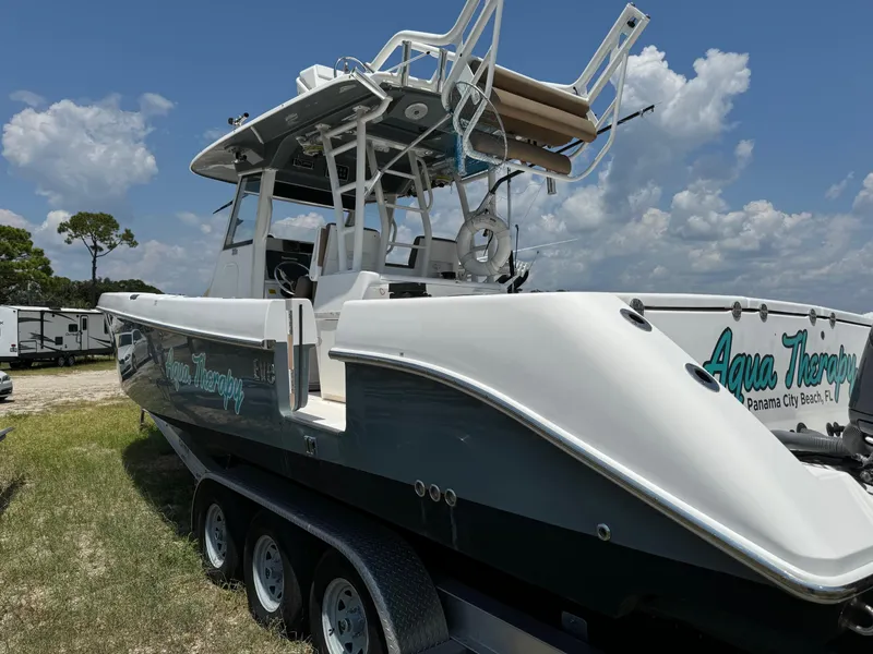 Slide: The Image of 2013 Everglades 355 Tournament boat on trailer, "Aqua Therapy" text, sunny day. - 6