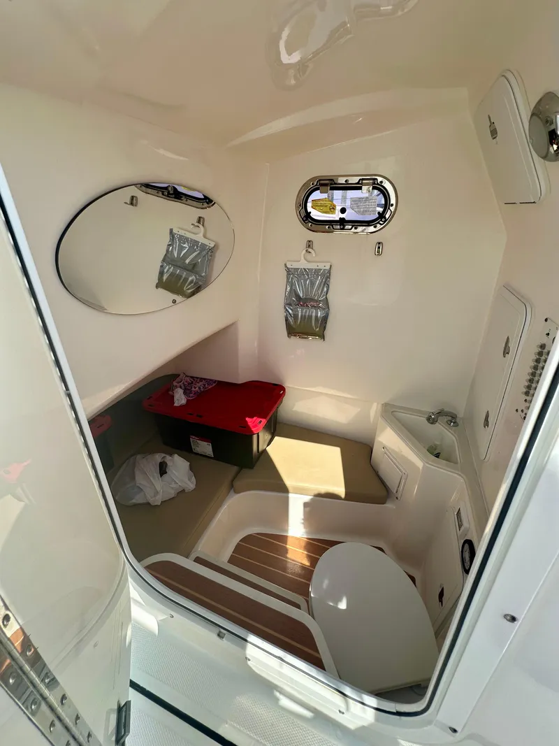Slide: The Image of 2019 Edgewater 280CC boat interior cabin with sink, mirror, and porthole window. - 10