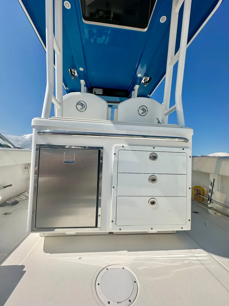 Slide: The Image of 2019 Edgewater 280CC boat interior with storage drawers and stainless steel compartment. - 16