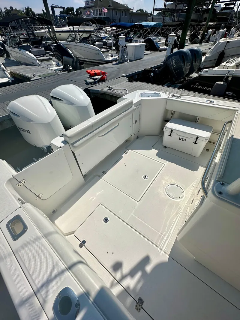 Slide: The Image of 2019 Edgewater 280CC boat with spacious deck and twin engines at marina. - 18