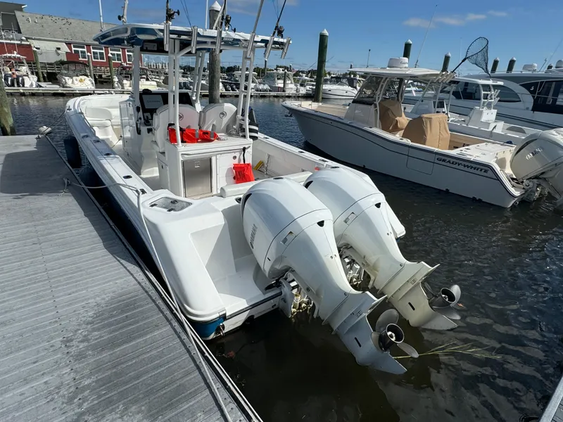 Slide: The Image of 2019 Edgewater 280CC boat docked with twin outboard engines in a marina. - 20