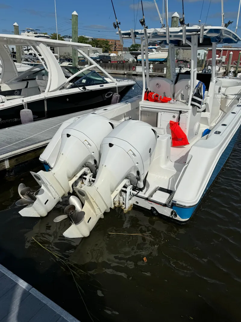 Slide: The Image of 2019 Edgewater 280CC boat with dual outboard motors docked at marina. - 21