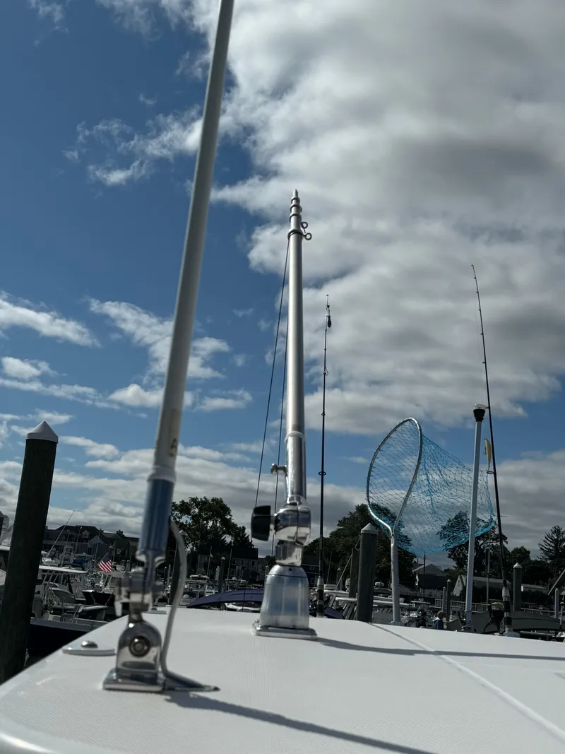 Slide: The Image of 2019 Edgewater 280CC boat docked under a partly cloudy sky. - 23