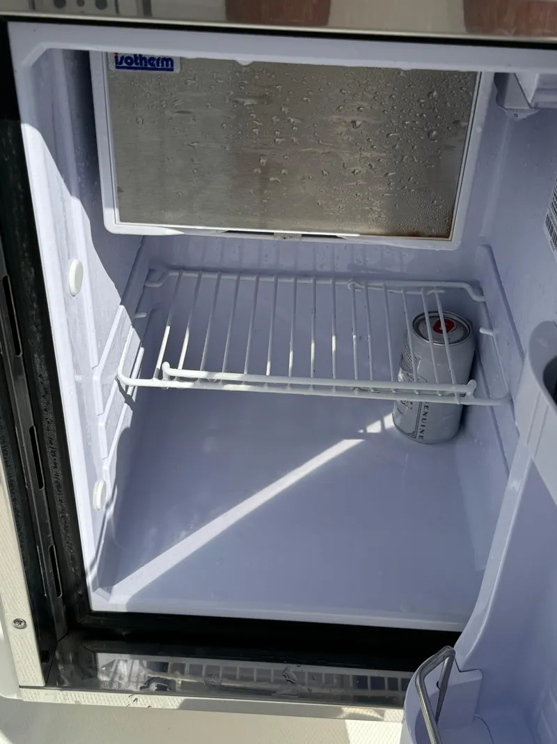 Slide: The Image of Open mini fridge with a single beverage can inside, aboard a 2019 Edgewater 280CC boat. - 25