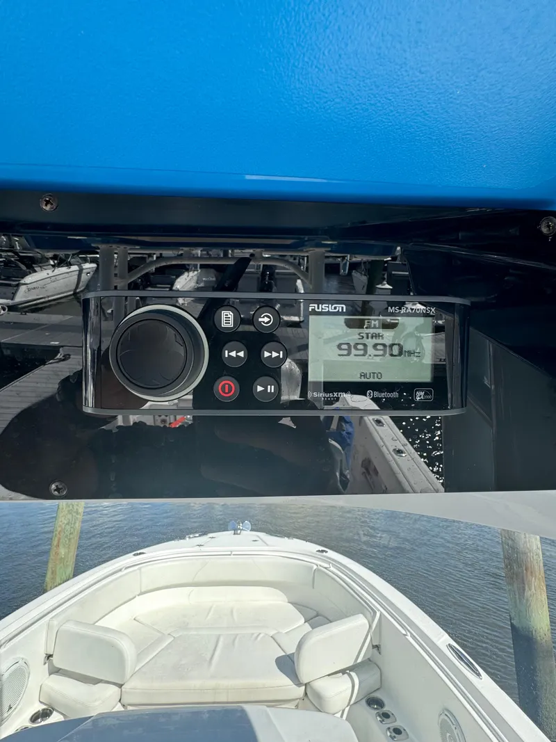 Slide: The Image of 2019 Edgewater 280CC boat with Fusion stereo system, docked on calm water. - 29