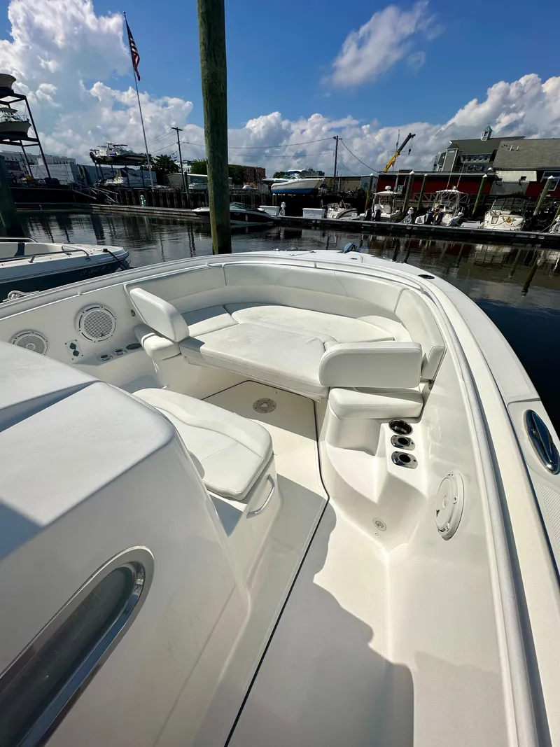 Slide: The Image of 2019 Edgewater 280CC boat with spacious seating, docked at a marina under a blue sky. - 3
