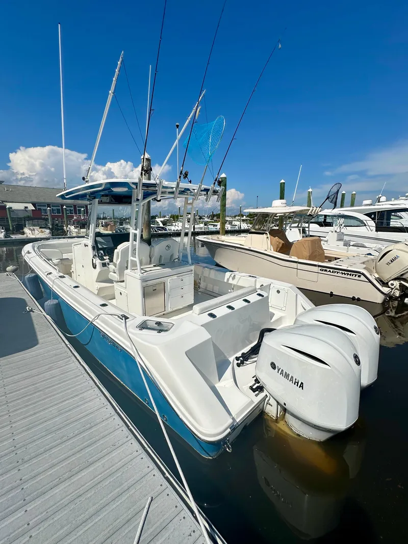 Slide: The Image of 2019 Edgewater 280CC boat docked with Yamaha engines under a clear blue sky. - 7