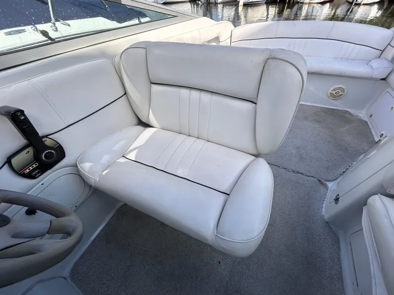 Slide: The Image of Interior of 2000 Crownline 266 CCR boat with white seating and steering wheel. - 14