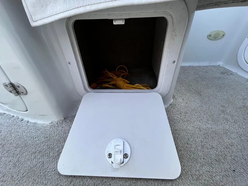 Slide: The Image of Open storage compartment on 2000 Crownline 266 CCR boat with yellow rope inside. - 18